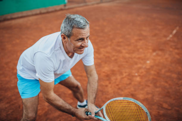 istock Older man holding tennis racket on court 1167173087