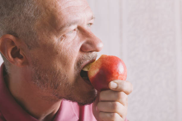 istock Adult man eating fresh ripe nectarine 1167173767