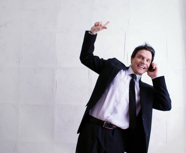 There's an idea! On the way to success. Business life. Purposeful attractive businessman, talking on the smartphone, smiles and shows a finger up. stock photo