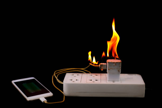 istock On fire Adapter smart phone charger at plug in power outlet at black background 1167175782