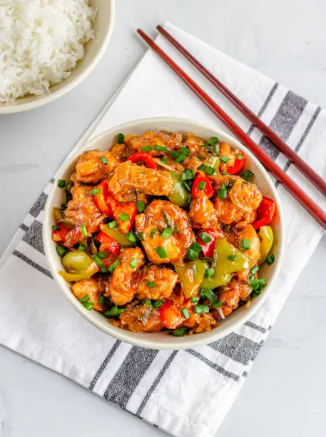 Sweet and Sour Chicken with Rice and Chopsticks Directly Above Photo.