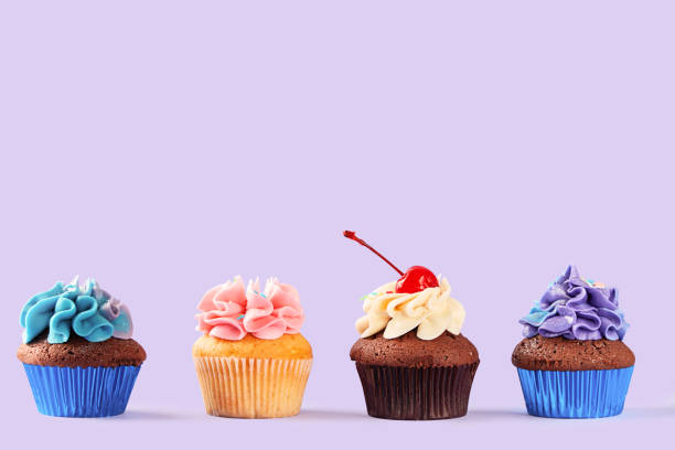 Cupcakes variety on a purple background. Sweet food. Copy space stock photo