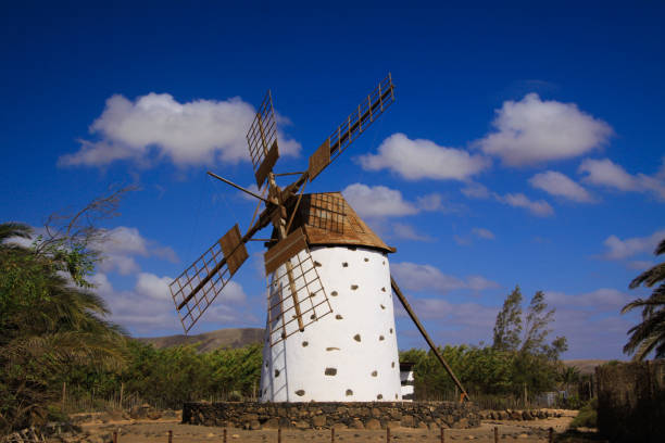 istock View on isolated ancient white windmill with brown wings against blue sky with few scattered clouds 1167177618