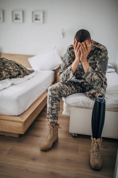 istock Sad veteran soldier sitting in bedroom alone 1167180283