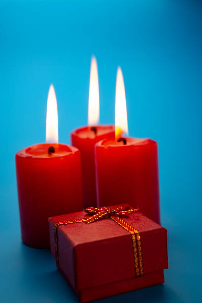 istock red gift box and burning red candles on a blue background. 1167180823