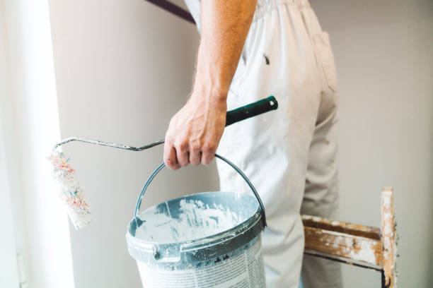 istock Man hand holding a bucket of paint and a paint roller 1167186839