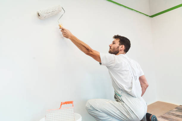 istock Painter holding a paint roller, painting the room white 1167186860