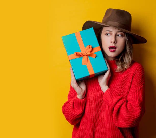 istock Young surprised woman in red sweater with gift box 1167187305