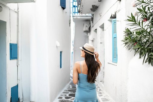 Oia, Santorini, Greece - July 3, 2021: Tourists while walking through the narrow streets of Oia, Santorini, Greece