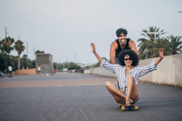 istock Couple having fun with skateboard on the street 1167188399