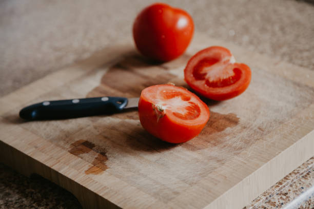 istock Cut red tomato lies on wooden board 1167188525