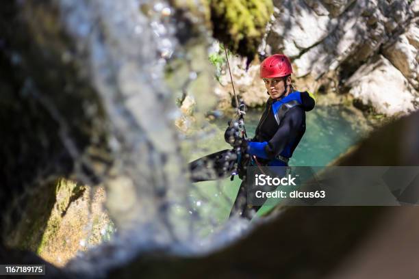 Girl Rappelling In The Canyon Adventure With Waterfall And Turquoise Water In The Background Stock Photo - Download Image Now