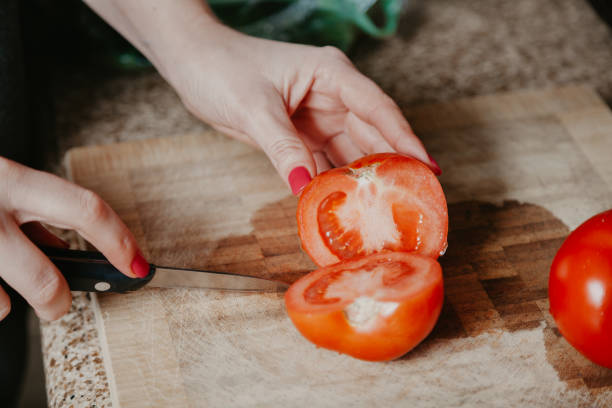 istock Woman hands cut red tomato 1167189176