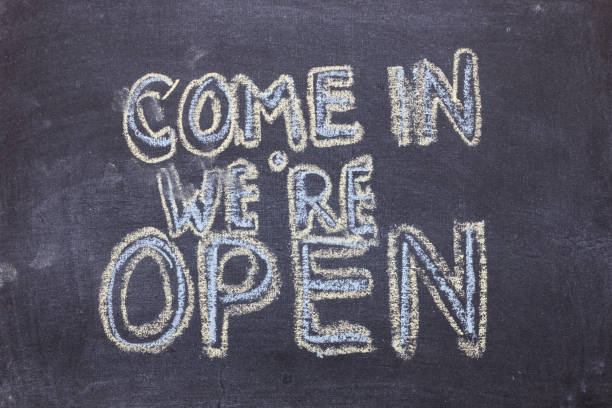 istock Come in we're open. Chalk lettering on blackboard. Multi colored inscription 1167189216