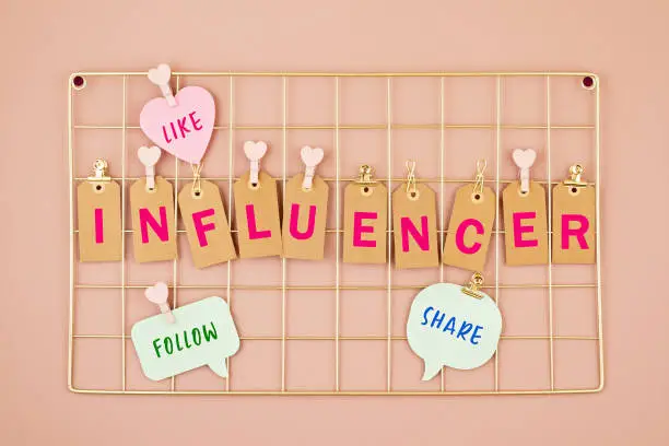 Influencer text on the golden colored mesh board. Social networking concept