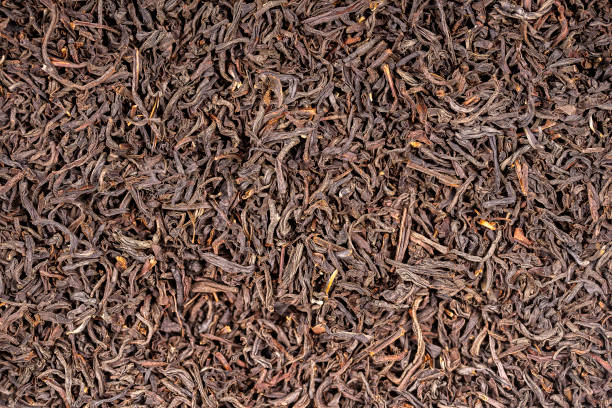 istock Black tea leaves background. Abstract food textures. Close up 1167189818
