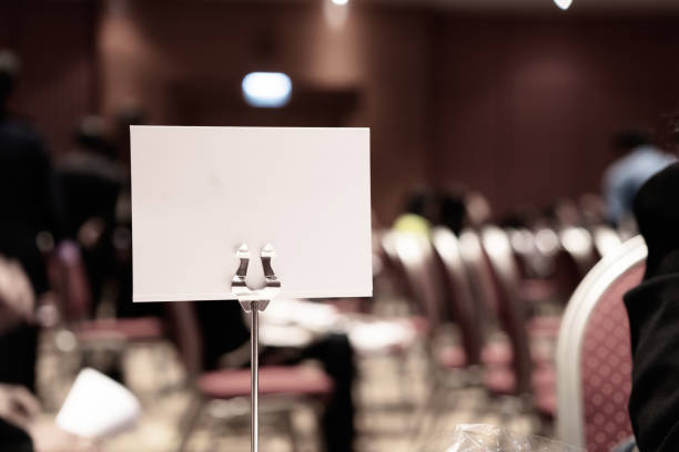 istock Mock up white Label for blank menu frame in seminar room or conference hall light on desk groups for letter, Event Background. Business Talk Presentation. 1167189823