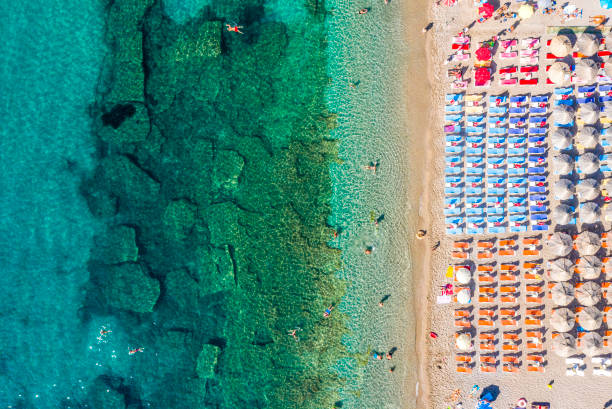 mar de jade con corales en el agua, y una playa llena de tumbonas y sombrillas, disparado desde un dron por encima - mushroom edible mushroom water splashing fotografías e imágenes de stock