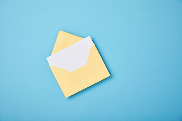 istock yellow envelope with blank white card on blue background 1167194086