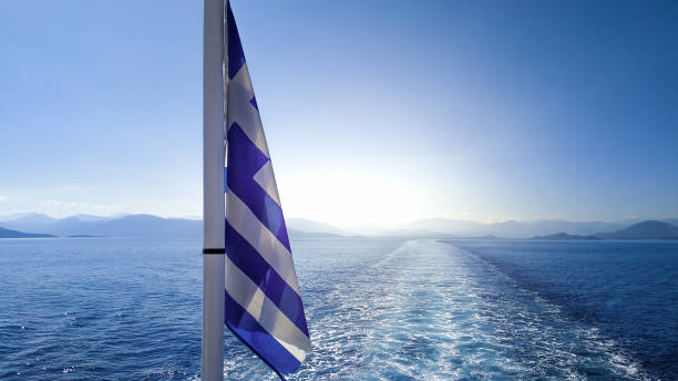 Greece flag on a sailing cruise ship boat sailing to the tourist summer travel vacation destinations. stock photo