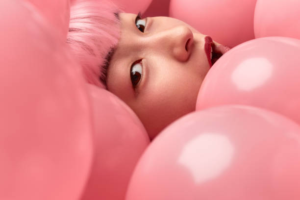 face of amazed asian woman in pink balloons - fashion model pink beauty fashion imagens e fotografias de stock