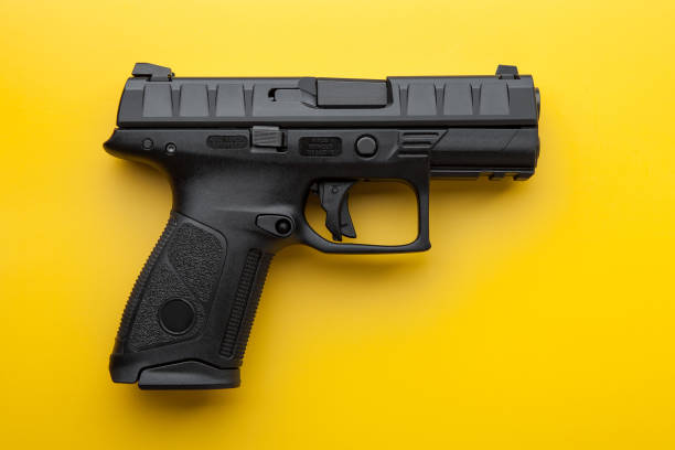 istock Modern black semi-automatic pistol on a bright yellow background. Short-barreled weapons for the military, police, athletes and for self-defense. 1167198389