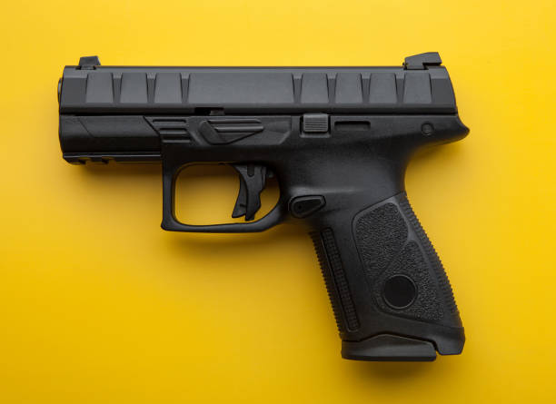 istock Modern black semi-automatic pistol on a bright yellow background. Short-barreled weapons for the military, police, athletes and for self-defense. 1167198395