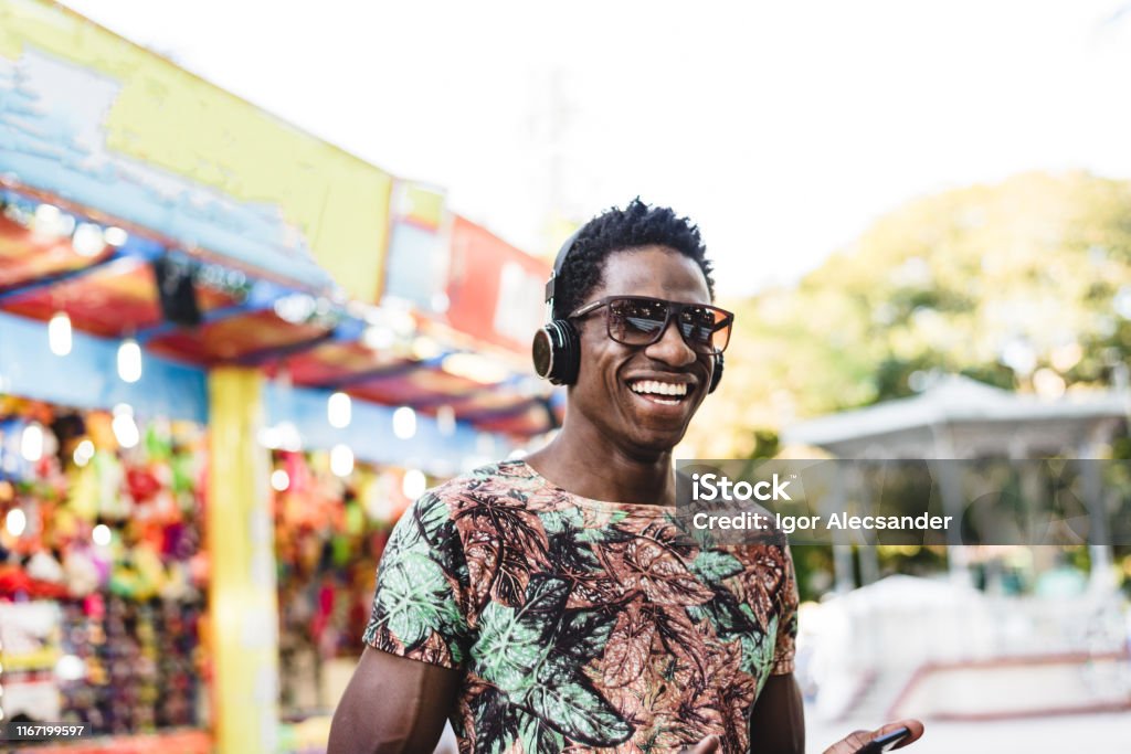 Man with headset at the amusement park All the fun of the fair, friends having fun at the festival park. Music Festival Stock Photo