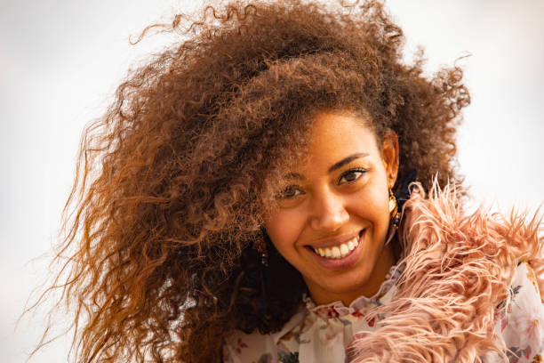 istock A warm colored sunset outdoors in the beach. A beautiful and smiling young boho styled woman 1167201521