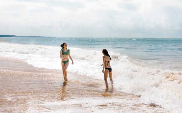 istock Two young girls happily spending their vacations at the beach 1167201731