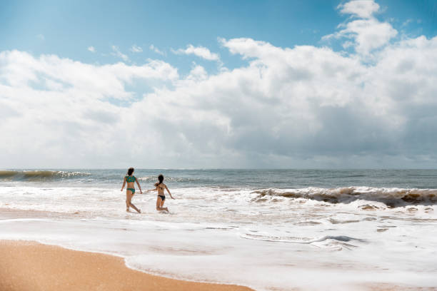 istock Two young girls happily spending their vacations at the beach 1167201733