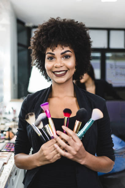 porträt eines lächelnden make-up-künstlers, der pinsel hält - owner hair salon beauty spa female stock-fotos und bilder