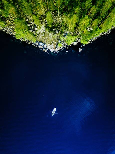 vista aérea do lago azul com um barco de pesca e as florestas verdes com as rochas em finlandia. - pier rowboat fishing wood - fotografias e filmes do acervo