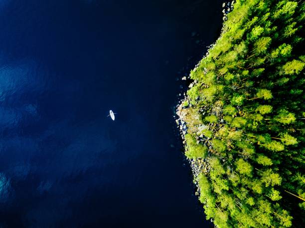 vista aérea del lago azul con un barco de pesca y bosques verdes con rocas en finlandia. - pine wood forest river fotografías e imágenes de stock