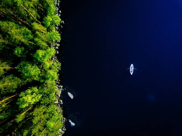 vista aérea do lago azul com um barco de pesca e as florestas verdes com as rochas em finlandia. - pier rowboat fishing wood - fotografias e filmes do acervo