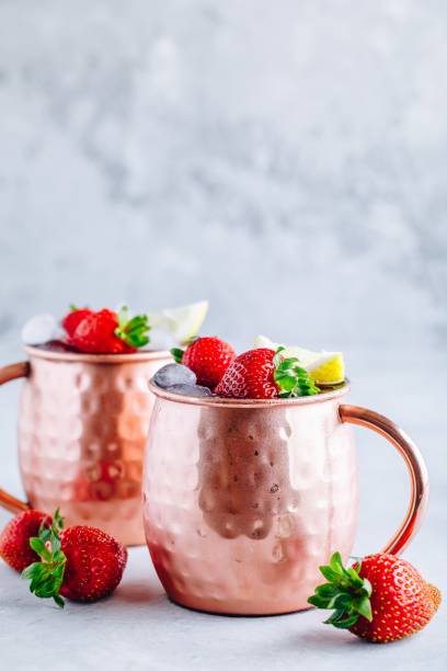 istock Refreshing iced Moscow mule alcoholic cocktail in copper mugs with strawberry and lemon 1167210821