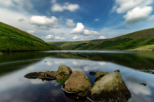 Long exposure shot on a sunny morning of Greenfield Reservoir in the Peak District