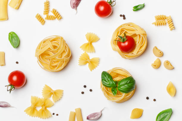 istock Various uncooked pasta on white background. Top view. Raw pasta with ingredients for cooking. Food concept 1167213485