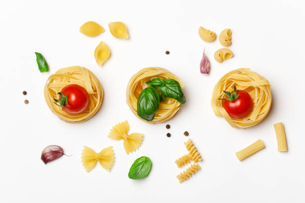 Various uncooked pasta on white background. Top view. Raw pasta with ingredients for cooking. Food concept