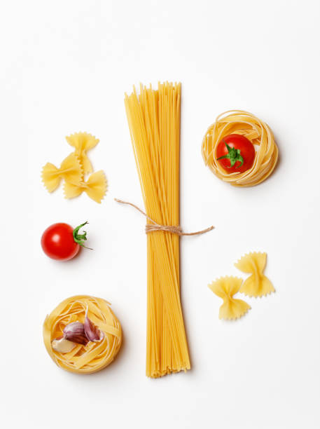 istock Various uncooked pasta on white background. Top view. Raw pasta with ingredients for cooking. Food concept 1167213568