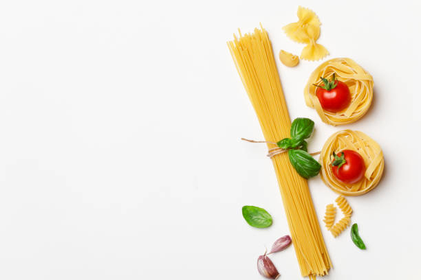 istock Various uncooked pasta on white background. Top view. Raw pasta with ingredients for cooking. Food concept 1167213581