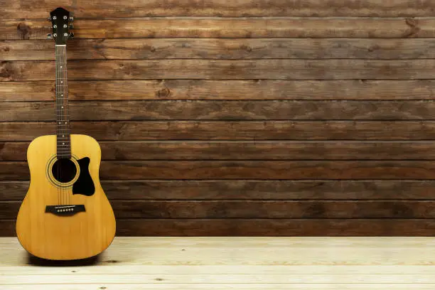 acoustic guitar near a beautiful wooden wall, place for text