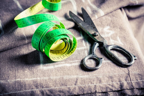 istock Closeup of tape measure and scissors on cloth 1167217617
