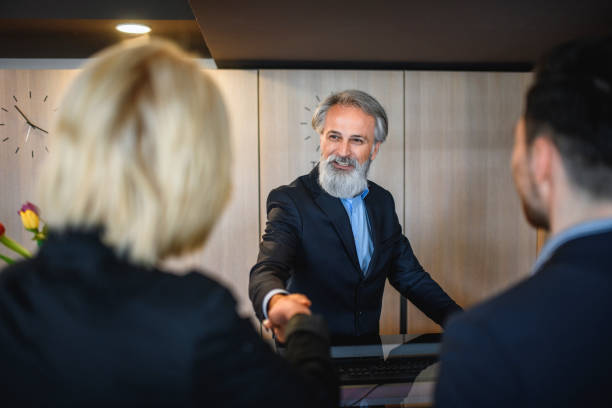 istock Cheerful Hotel Receptionist Shaking Hands with Female Guest 1167221185