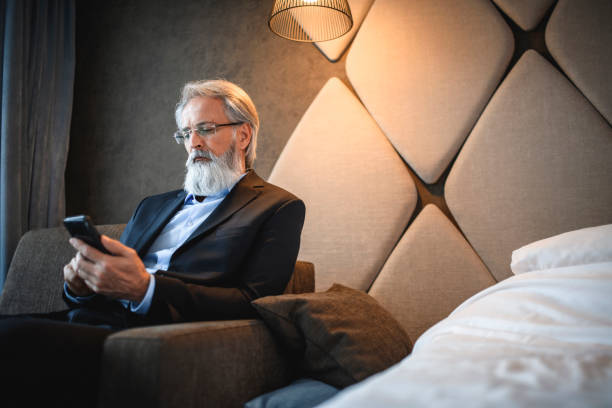 istock Mature Business Executive Using Smart Phone in Hotel Room 1167221635