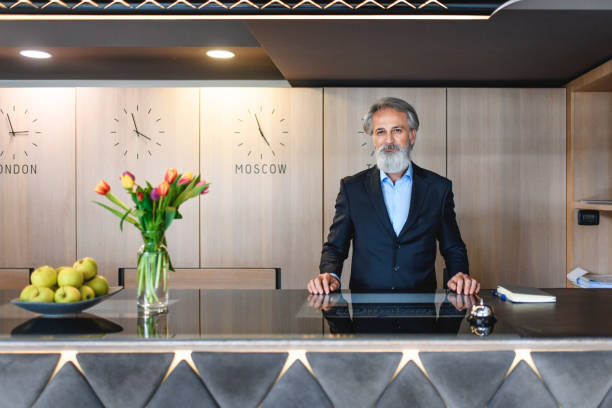 istock Welcoming Senior Hotel Receptionist at Front Desk 1167221683