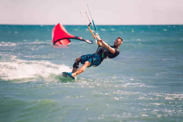 istock Kitesurfing. Man rides on kite on waves 1167224437