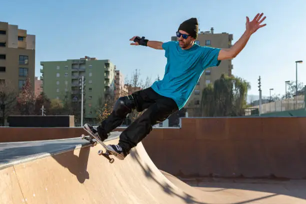 Skateboarder on a grind at sunset at the local skatepark.