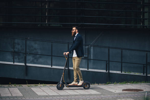 istock Hipster in a suit riding an electric scooter 1167233402