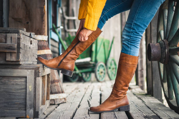 woman fasten zipper on her leather boots. - fashion women denim farm imagens e fotografias de stock